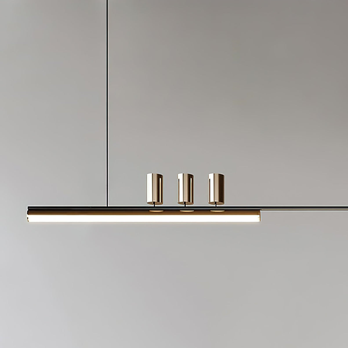 Close view of the three cylinder heads and the lit underside of the bar on this Clérachic pendant.