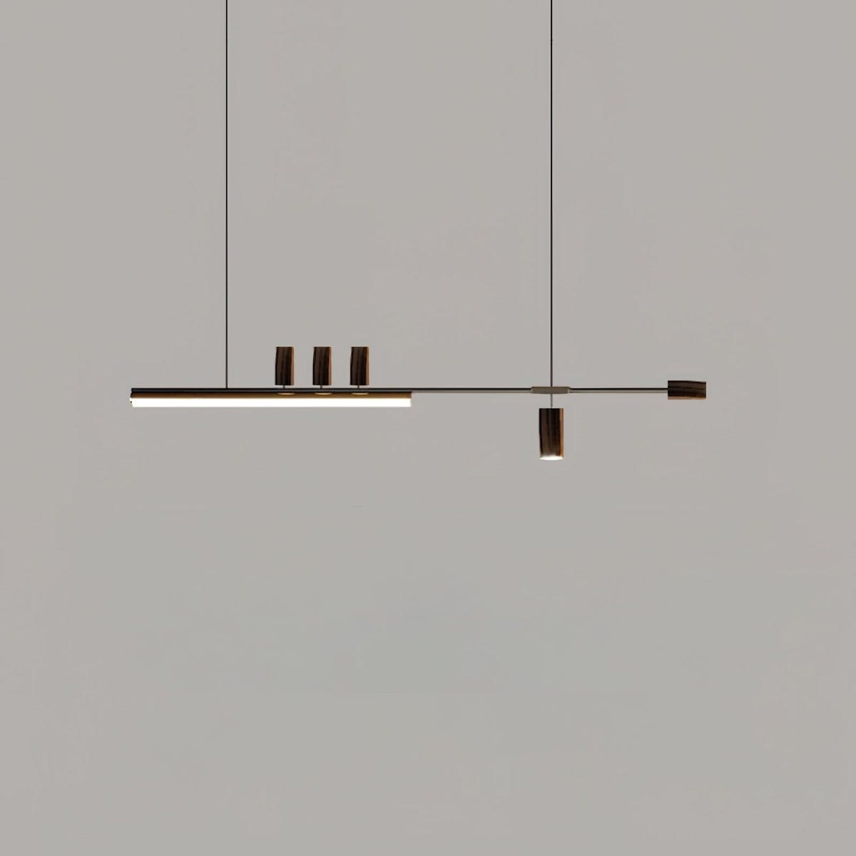 Another dark-toned view of this Clérachic pendant on grey, with the bar lit and the top cylinders and end cap in deep brown.