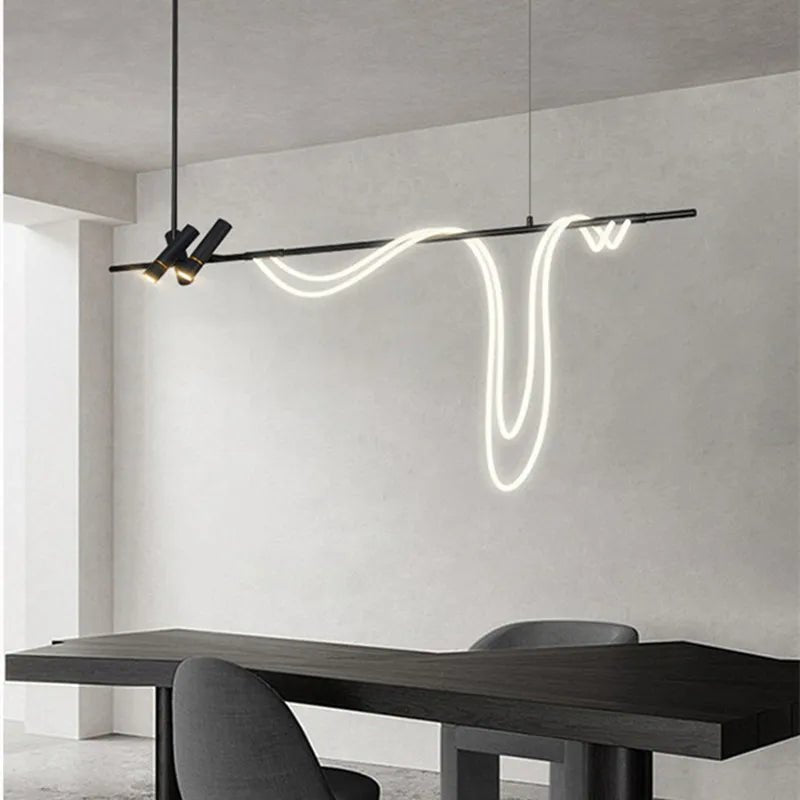 Clérachic black bar pendant with two angled spot heads and a looping white LED tube over a dark table in a pale room.