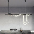Clérachic black bar pendant on two cables with a looping white LED tube and spot heads, in a grey room above a dark table.