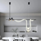 Clérachic black bar pendant with a looping LED tube and two glowing spheres, hung above an oval marble dining table in a room.