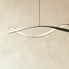 Close view of the Clérachic pendant's twisting ribbon, a black outer band wrapped around a softly glowing white LED strip.