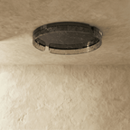 Clérachic round ceiling light switched off, showing the black metal frame and smoky marbled glass ring on a limewashed ceiling.