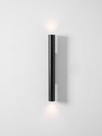 A tall Clérachic wall light throws a faint glow above and below it on a pale, clean wall.