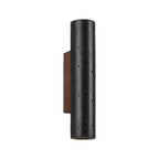 A black travertine cylinder on a walnut plate, unlit, in a Clérachic wall light shown against a plain white backdrop.