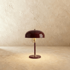 Clérachic dome table lamp in red enamel with a brass neck and base ring, photographed straight-on against a plain backdrop.