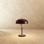 Clérachic dome table lamp in red enamel with chrome fittings, photographed from the front against a warm plain backdrop.