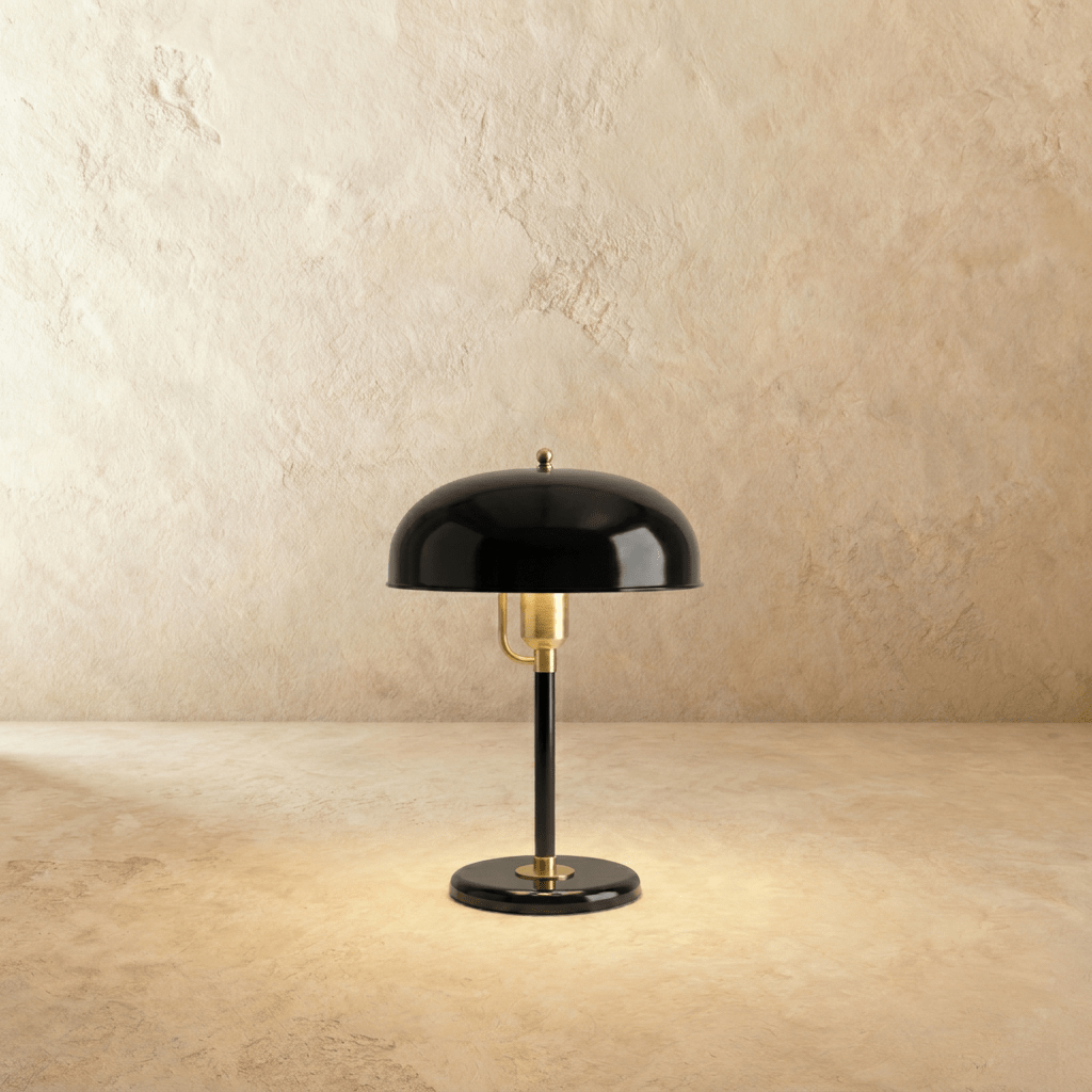Clérachic dome table lamp in glossy black enamel with a brass neck and base ring, photographed against a plain backdrop.