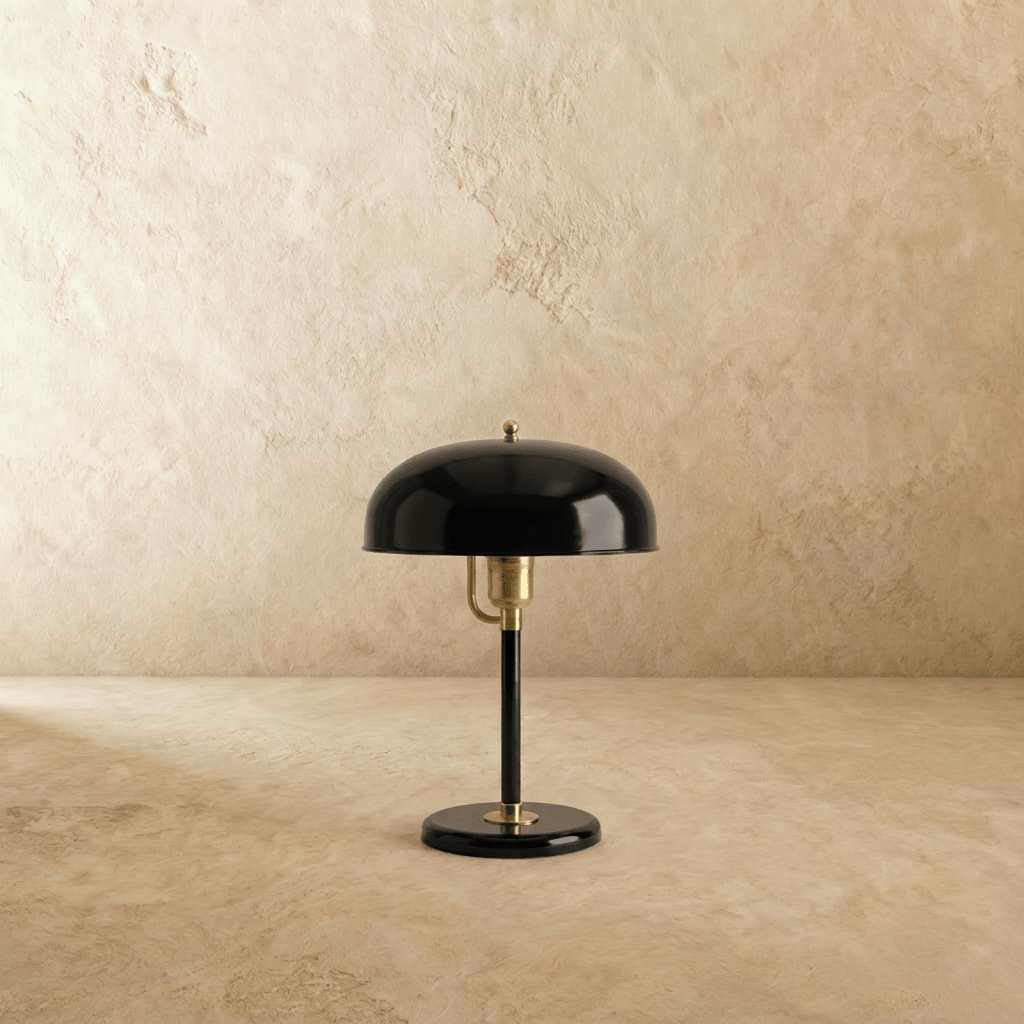 Clérachic dome table lamp in glossy black enamel with brass fittings, shown from a slightly different angle on a plain backdrop.