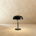 Clérachic dome table lamp in glossy black enamel with chrome fittings, photographed against a plain studio backdrop.