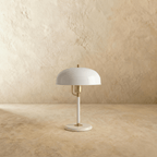 Clérachic dome table lamp in white enamel with brass fittings, shown from a slightly different angle on a plain backdrop.