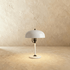 Clérachic dome table lamp in white enamel with black fittings, photographed against a plain studio backdrop.
