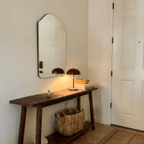Clérachic red dome table lamp with chrome fittings lit on a wooden console table beneath a mirror in an entryway.