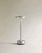 Clérachic's silver cordless table lamp stands upright, its slim aluminium column catching soft studio light.