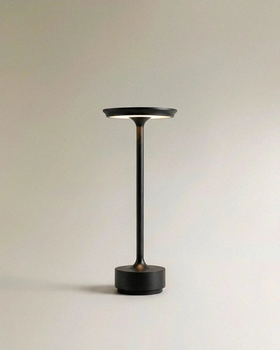 Clérachic's black cordless table lamp stands tall on a round base, its stem rising to a saucer shade.