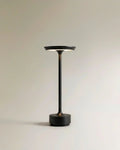 Clérachic's black cordless table lamp stands tall on a round base, its stem rising to a saucer shade.