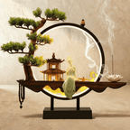 Clérachic incense-burner lamp lit warm, a seated jade-green Guanyin figure before a pagoda inside the ring.