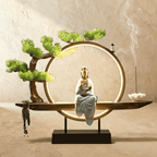 Clérachic incense-burner lamp lit bright gold, a seated white and gold Guanyin figure glowing within the ring.