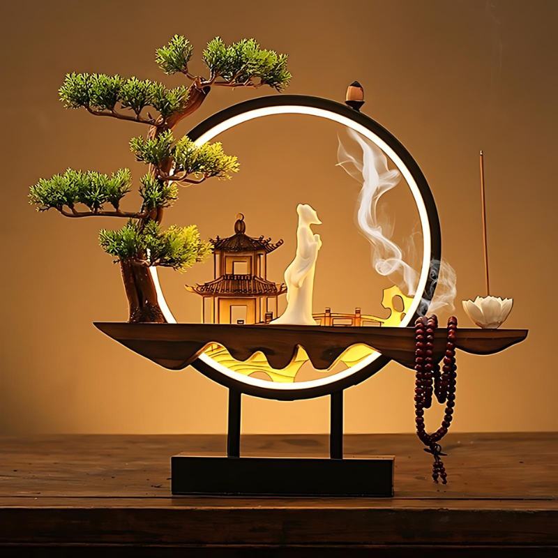 Clérachic incense-burner lamp on a wood table, a standing white figure and pagoda against warm amber light.