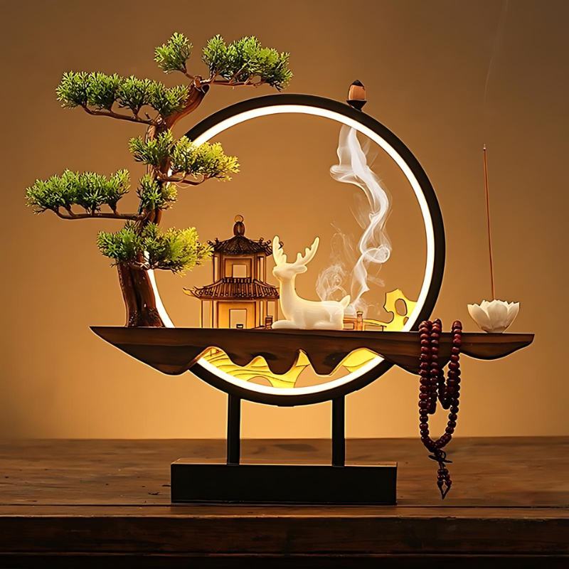 Clérachic incense-burner lamp lit warm on a wood table, a white deer figure beside a glowing pagoda scene.