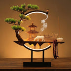 Clérachic incense-burner lamp lit warm on a wood table, a white ox figure beside a glowing pagoda scene.