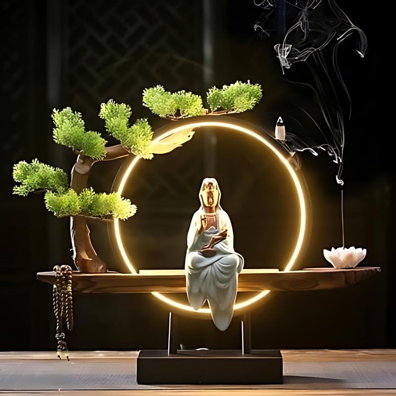 Clérachic incense-burner lamp lit bright gold against a dark backdrop, a seated white Guanyin figure glowing.