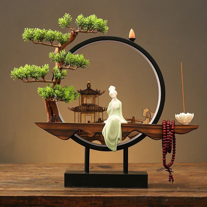Clérachic incense-burner lamp lit warm on a wood table, a seated jade-green Guanyin figure glowing softly.