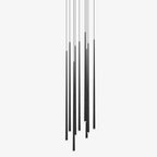 Cluster of slim black tapered tube pendants hanging at staggered heights against a plain white backdrop, from Clérachic.