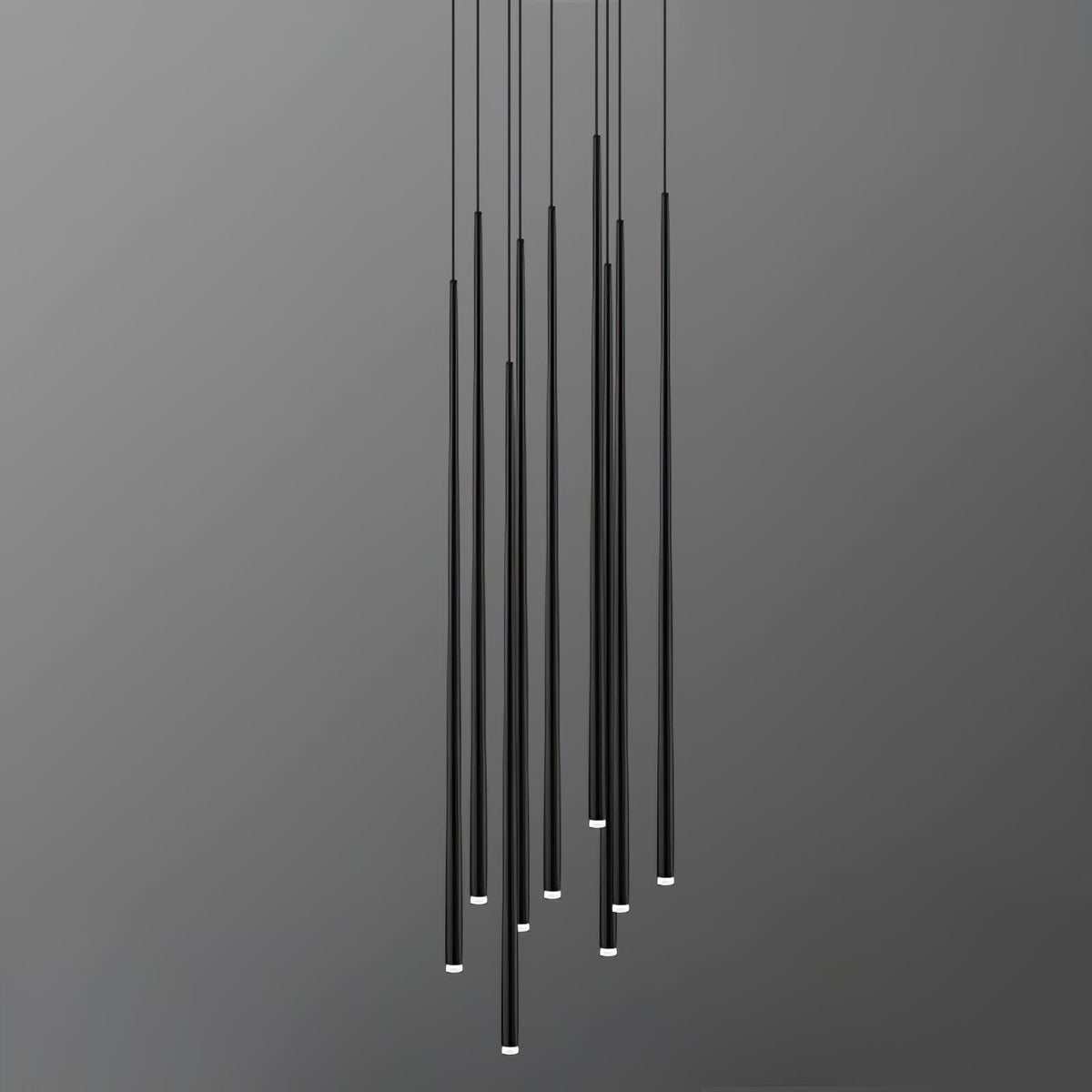 Dense cluster of long black needle pendants at uneven heights, tips lit, against a grey gradient backdrop, from Clérachic.