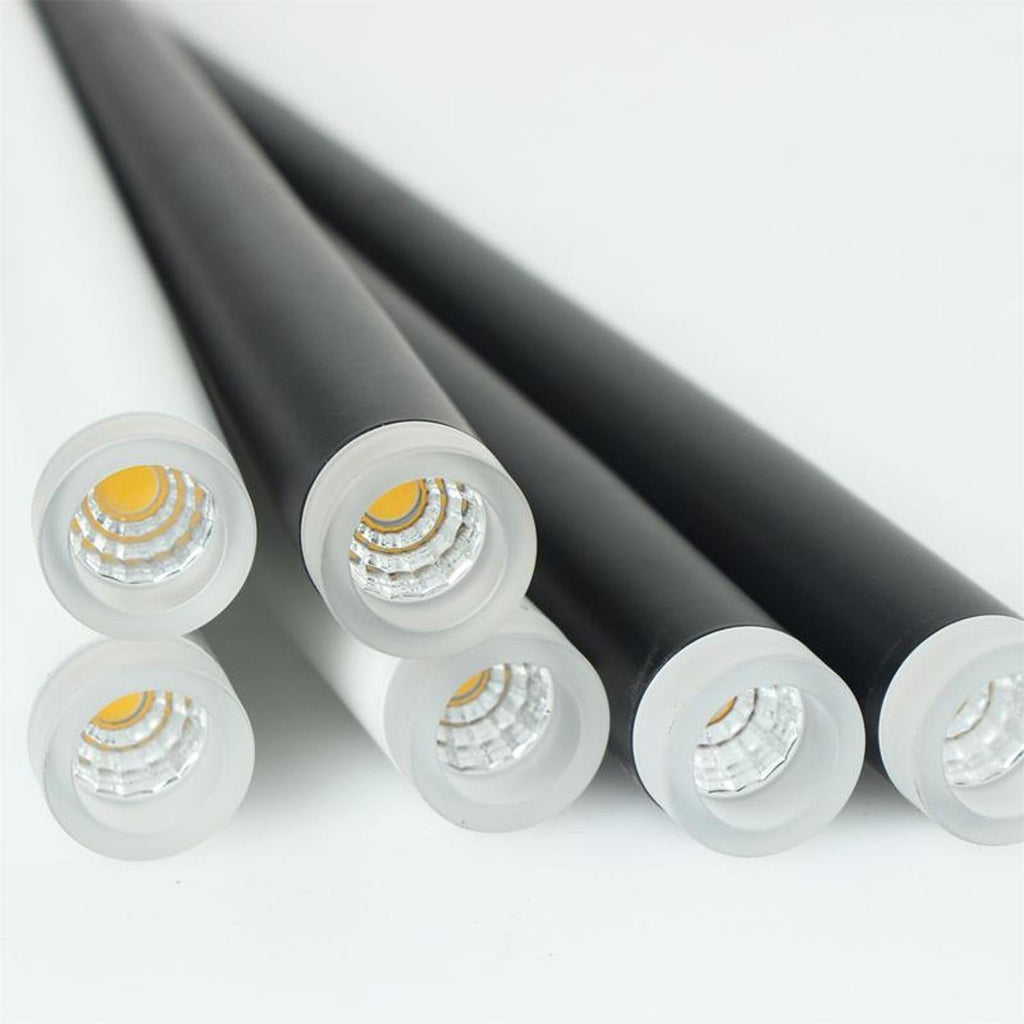 Close view of the frosted diffuser and LED at the tip of these Clérachic pendant tubes, one tube shown in white beside the black.