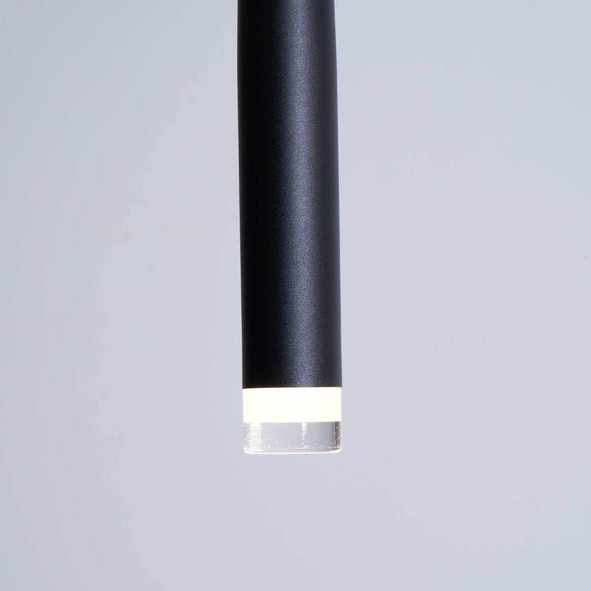 Close view of the matte black tube end and the frosted ring around the LED on this Clérachic pendant.