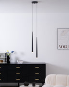 Pair of black cone pendants from a round canopy in a room with a black chest of drawers, a framed print and a cream chair, from Clérachic.
