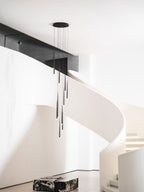 Pendant cluster hangs from a round black canopy by a white spiral staircase and a marble block, a Clérachic pendant.