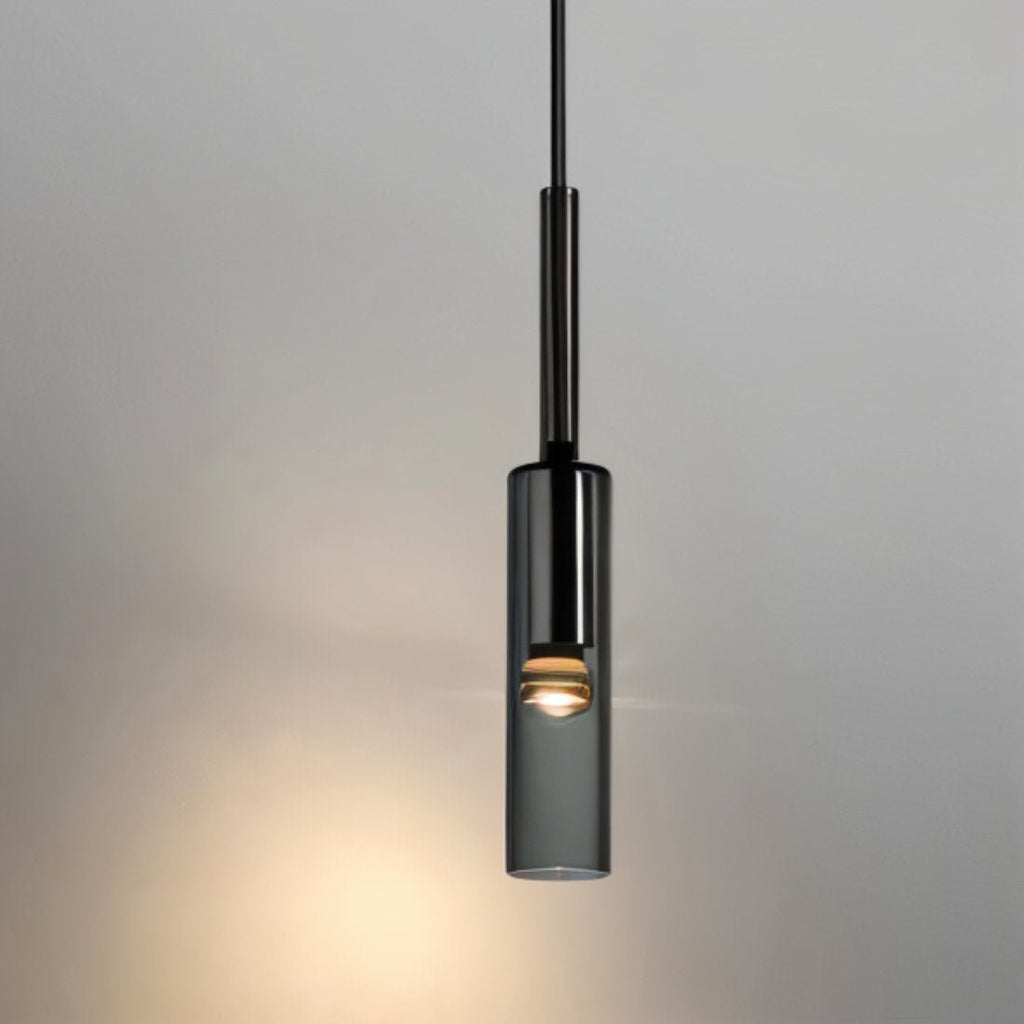 A single black-tinted glass pendant hangs lit on its slim rod against a plain grey wall in this Clérachic hero shot.