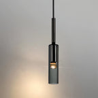A single black-tinted glass pendant hangs lit on its slim rod against a plain grey wall in this Clérachic hero shot.