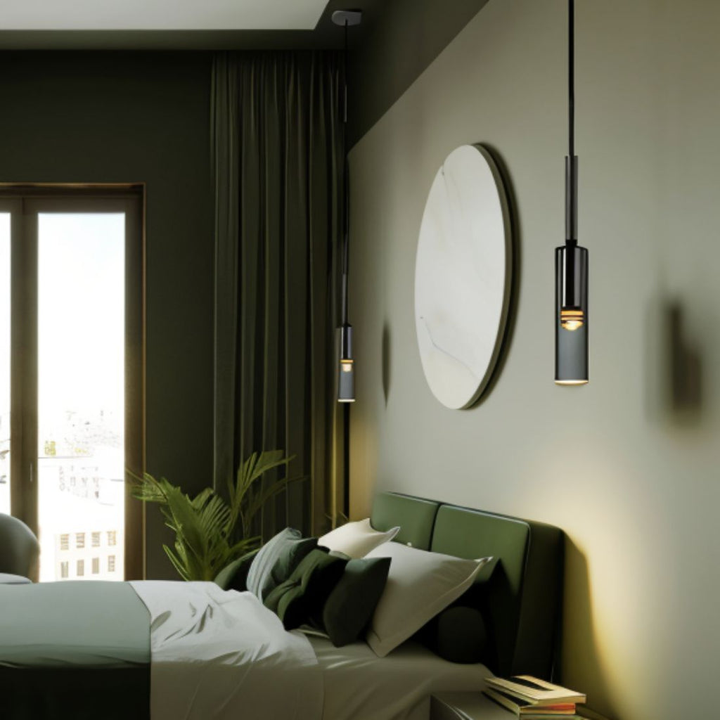 In a moss-green bedroom, two black-tinted pendants hang beside a stone mirror above an upholstered headboard, Clérachic lifestyle shot.