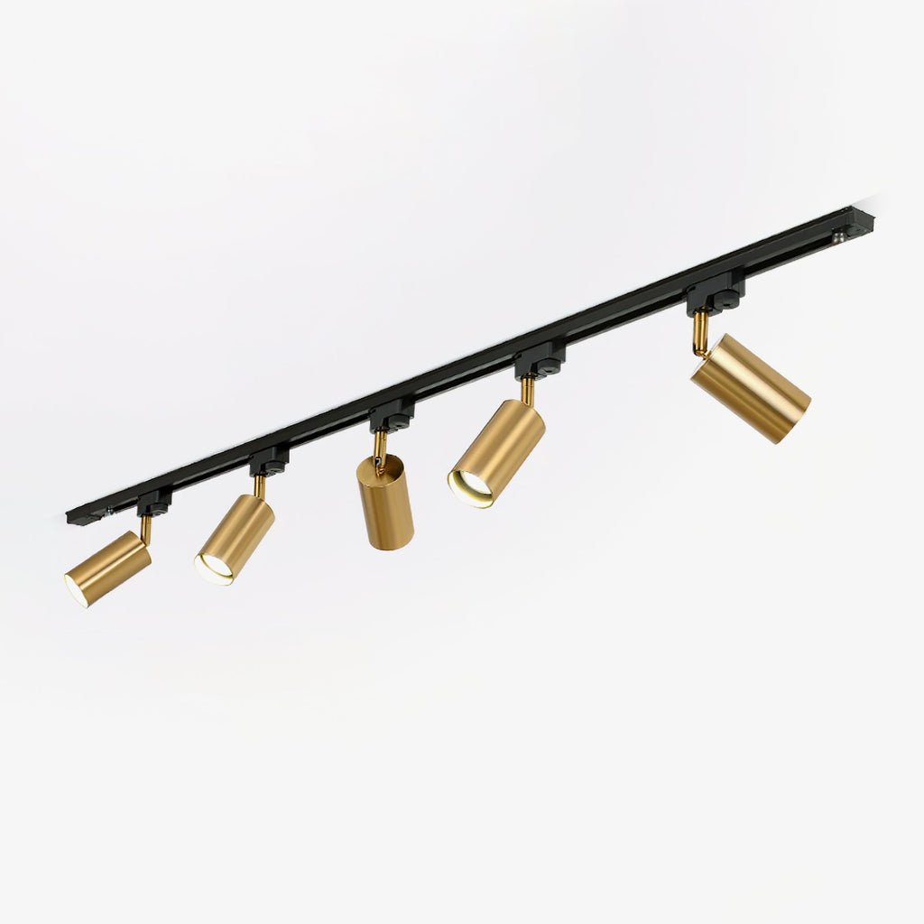 Black track light from Clérachic with five gold cylindrical heads set at different angles, on a plain white background.