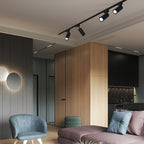 Black Clérachic track spotlights along a ceiling edge above a corner with a timber column, a blue chair and a mauve sofa.
