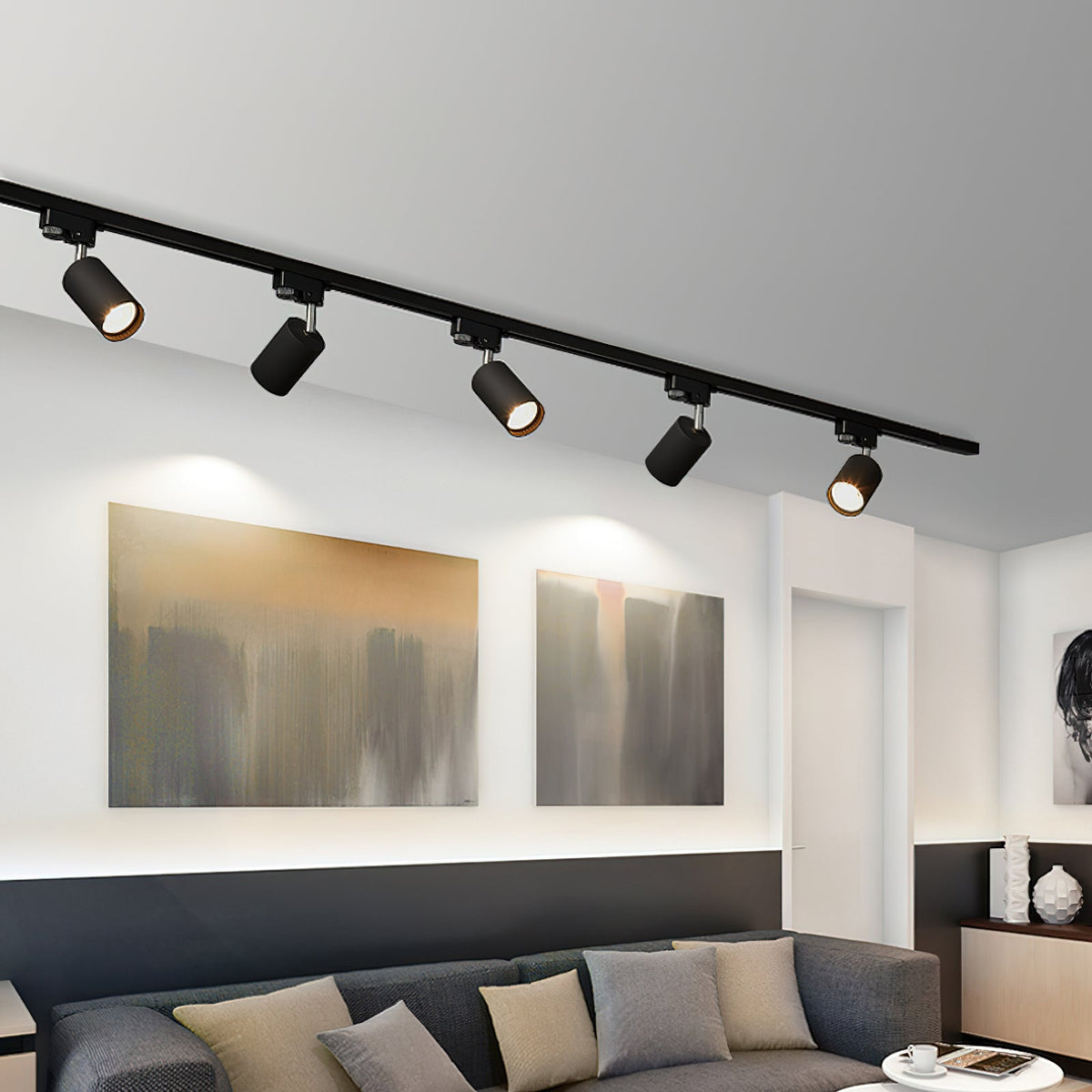 Five black Clérachic track heads on a straight track above a living room with two abstract paintings and a grey sofa.