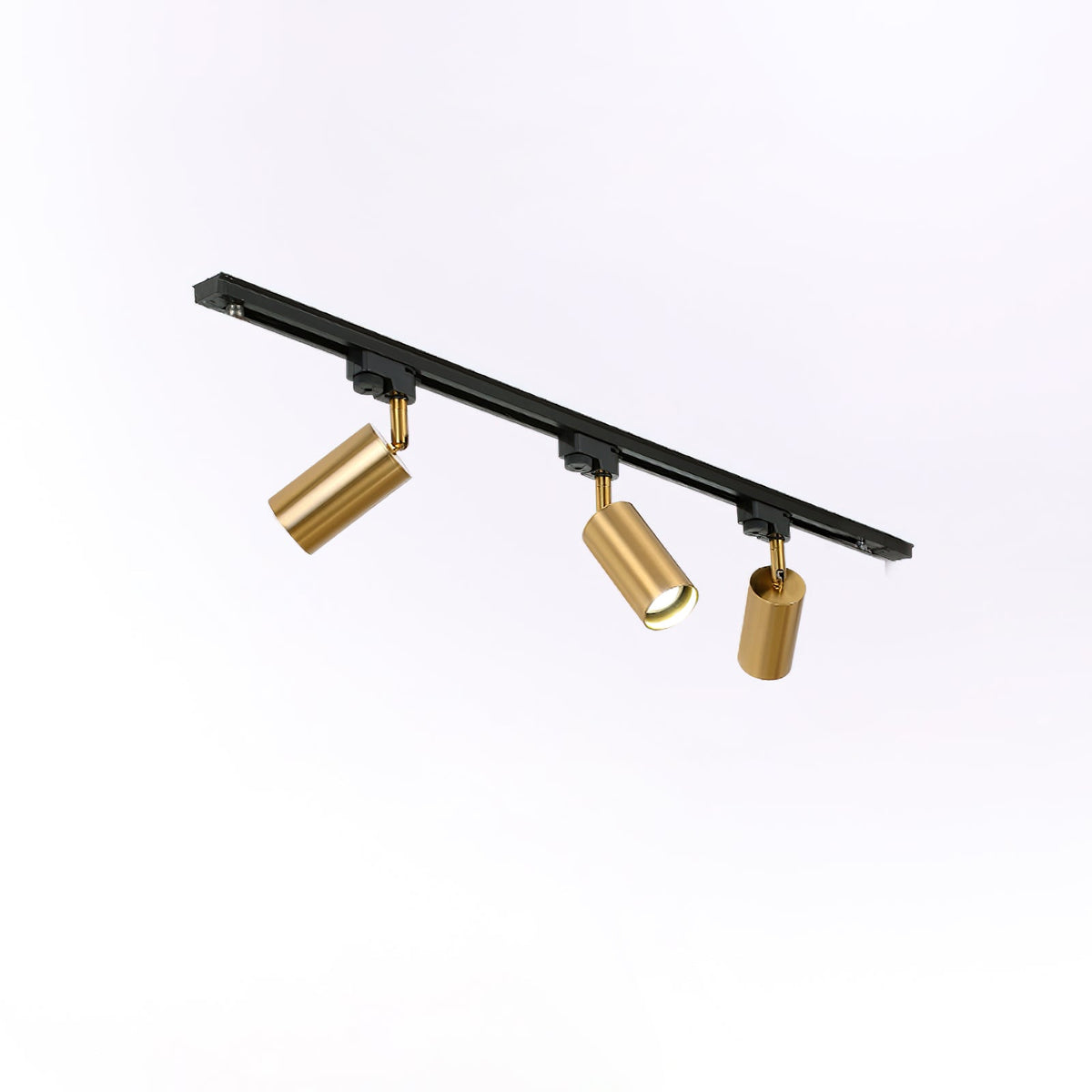 Three gold Clérachic spotlights on an angled black track, each head turned in a different direction, on white.
