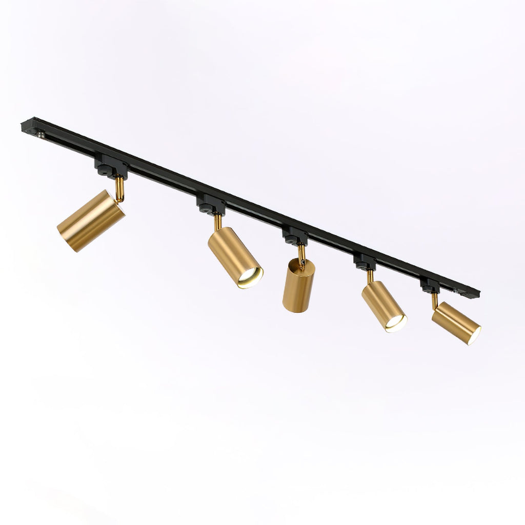 Five gold Clérachic spotlights on a black track, angled in different directions, shown on a pale backdrop.