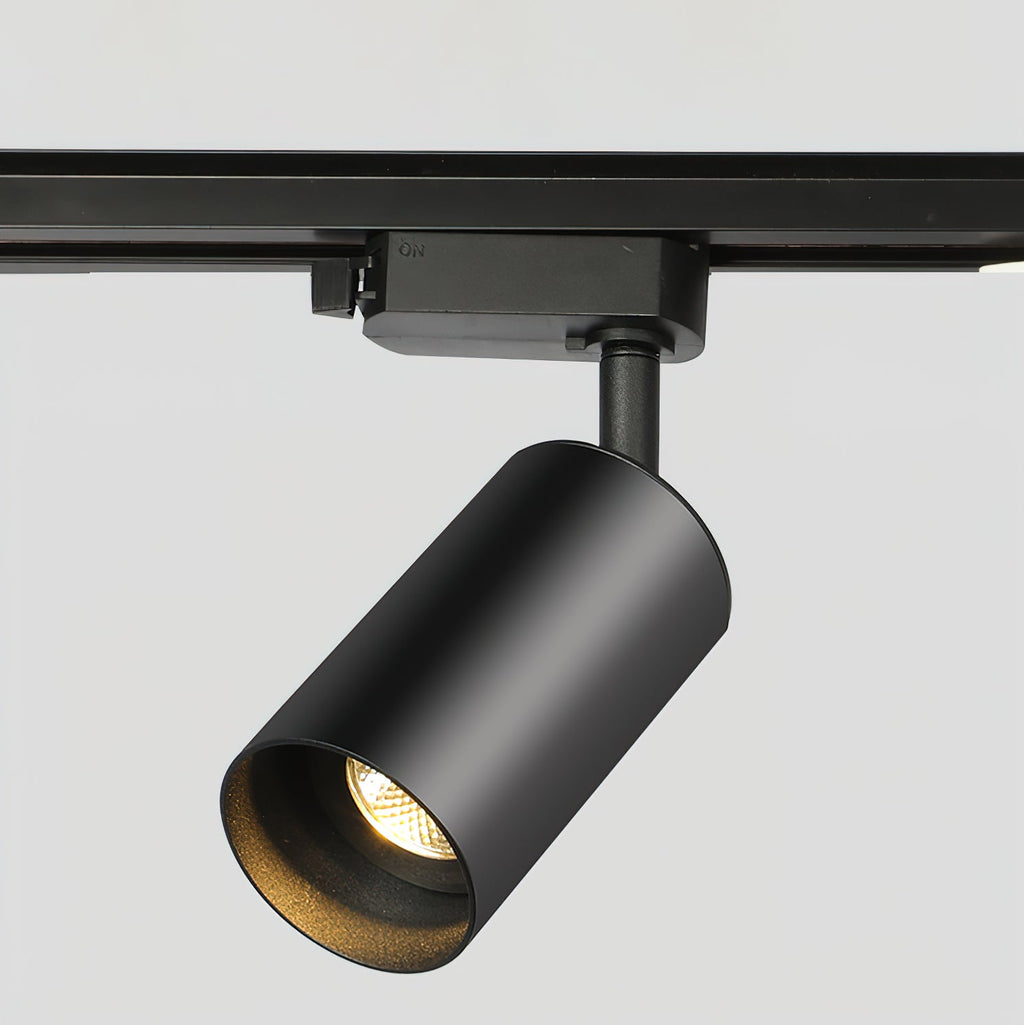 Close view of a black cylindrical Clérachic track spotlight, showing its adaptor, stem and recessed lens.