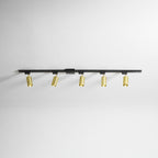 Clérachic black track with five gold spotlight heads, shown on a white ceiling with each head turned slightly.