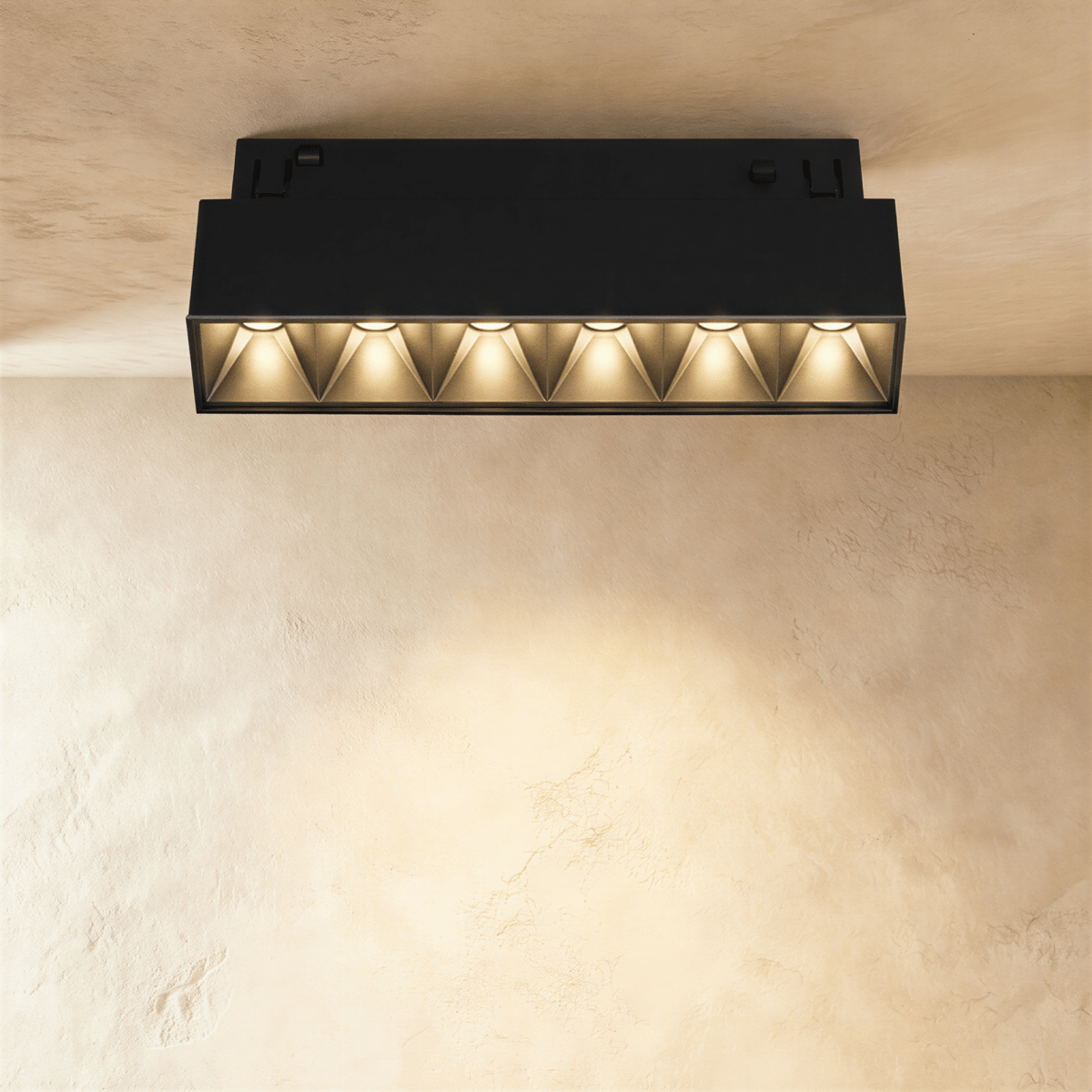 Clérachic compact black linear spotlight with six pyramid-lens cells, surface-mounted on a track rail overhead.