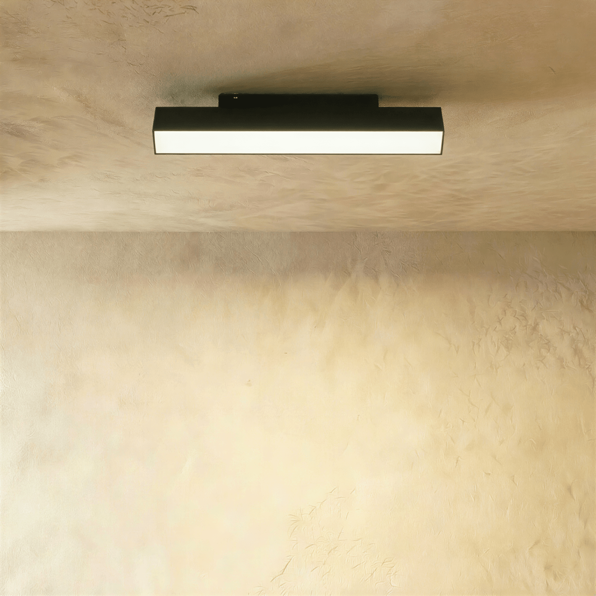 Clérachic elongated black linear floodlight bar with a bright frosted diffuser, mounted along a ceiling track rail.