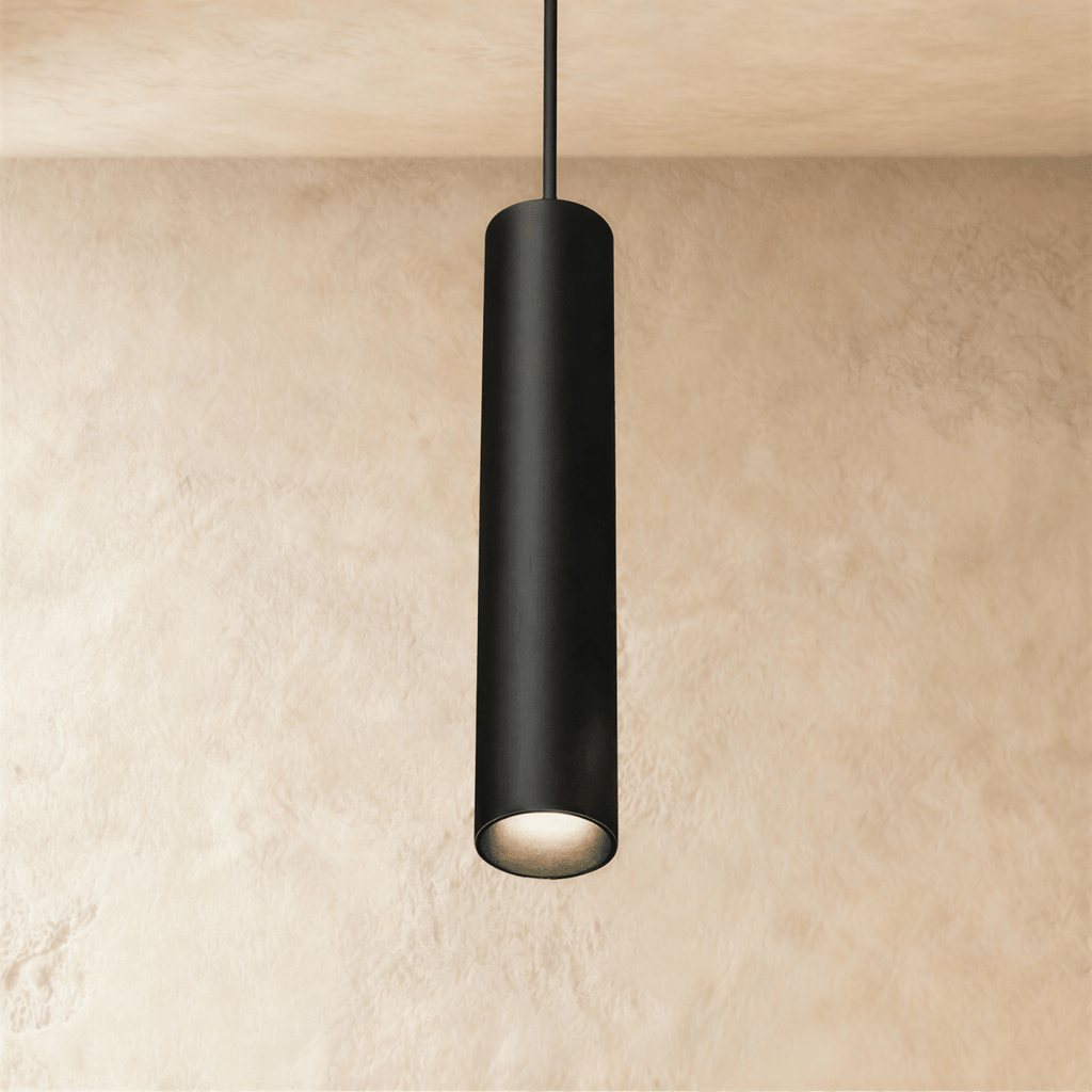 Clérachic slim black cylindrical pendant lamp hanging from a track rail on a cord, glowing warm at its open end.