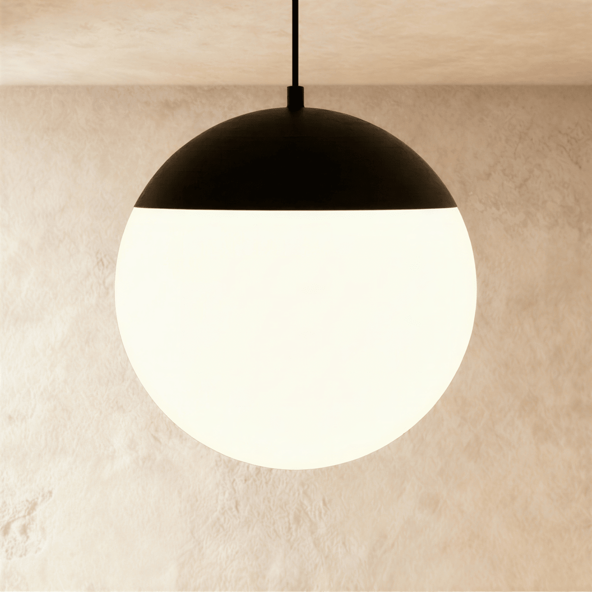 Clérachic black and white globe pendant lamp suspended on a cord from a ceiling track, glowing softly inside.