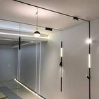Clérachic track lighting system shown installed across an open-plan room, mixing pendant, wall and ceiling heads.