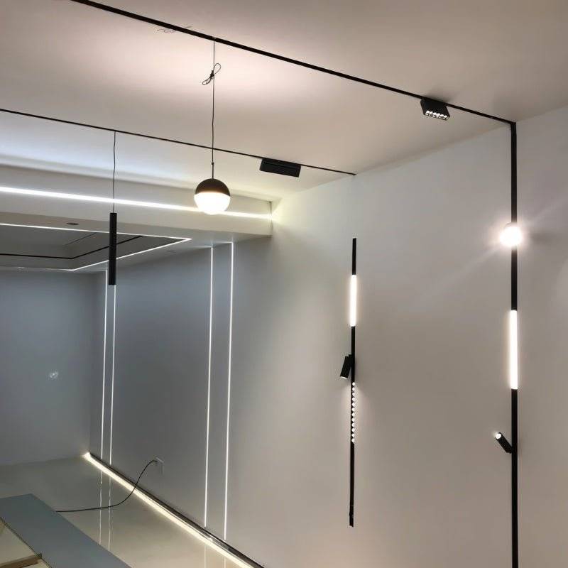 Clérachic track lighting system shown installed across an open-plan room, mixing pendant, wall and ceiling heads.
