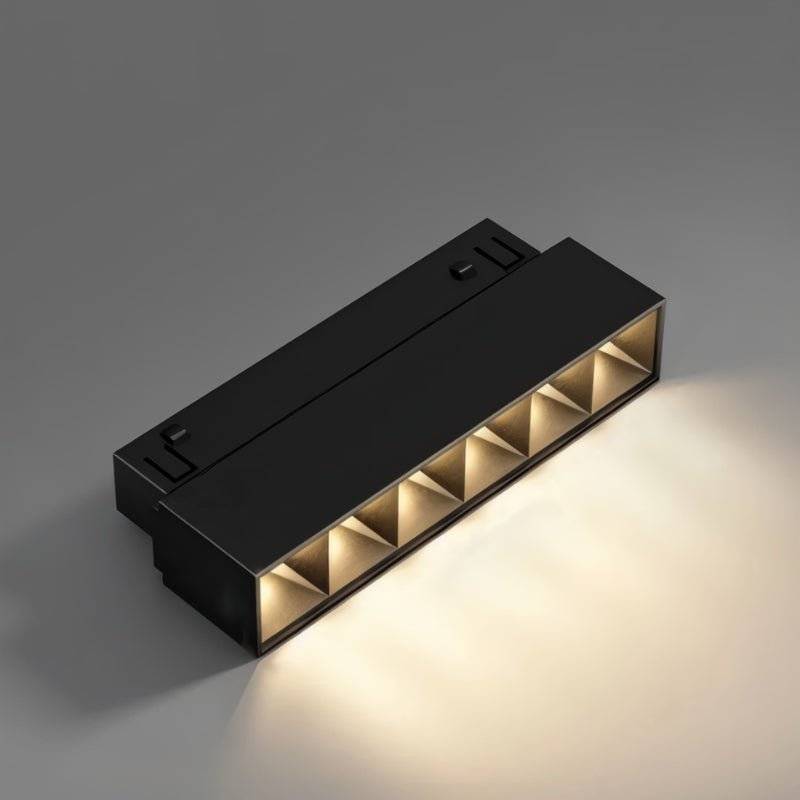 Clérachic black grille spotlight bar angled to show its six lit honeycomb cells against a plain grey backdrop.